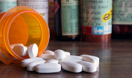 Prescription bottle on its side with white pills spilling out