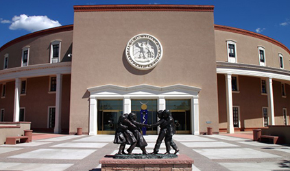 Round adobe building with sculpture in front